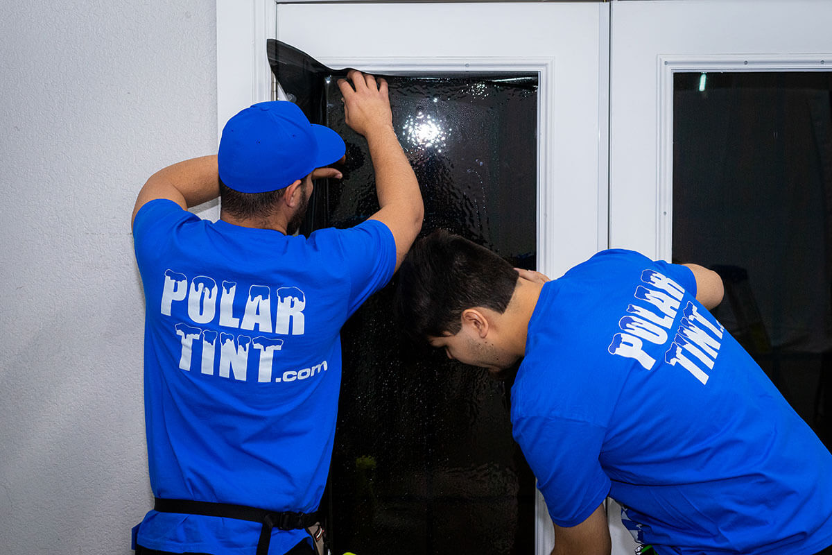 Anti-shatter security window film on a Parker storefront glass — smash-and-grab delay layer holding broken glass in the frame